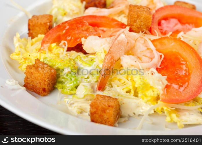 Salad of tiger shrimps, lettuce, chinese cabbage, tomato, garlic rusk, parmesan cheese and sauce