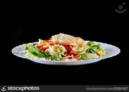 salad of vegetables and meat on black background