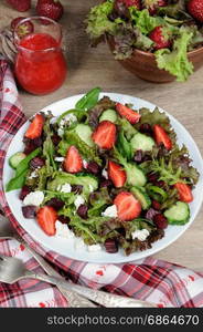 Salad of vinaigrette with strawberries, tender feta and strawberry sauce. Vertical shot.