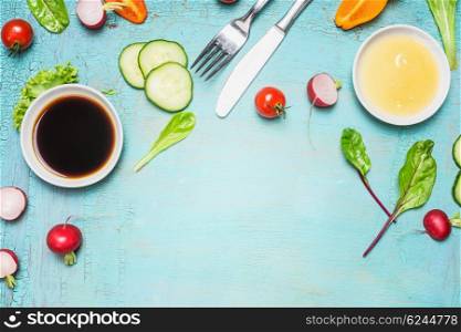 Salad preparation with cutlery dressing ingredients , lettuce , herbs and vegetables on light blue wooden background, top view, place for text. Healthy lifestyle or detox diet food concept
