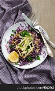 Salad red coleslaw with apple slices and crushed walnut