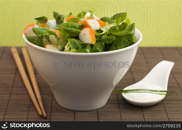 salad surimi and tzatziki. a photo of a cup of salad with surimi and tzatziki cream