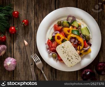 salad vegetables and cheese on wooden background, view from the top. dish on a wooden surface