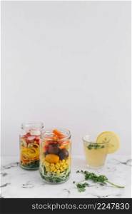 salad vegetables two mason jar with glass lemon juice marble top