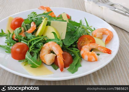 Salad with arugula and cherry tomatoes with shrimp, slices of apple and parmesan