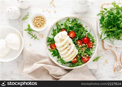 Salad with arugula, mozzarella cheese and pine nuts. Breakfast. Ketogenic, keto or paleo diet. Healthy food. Top view