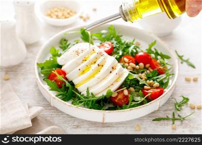 Salad with arugula, mozzarella cheese and pine nuts. Breakfast. Ketogenic, keto or paleo diet. Healthy food