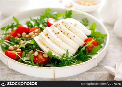 Salad with arugula, mozzarella cheese and pine nuts. Breakfast. Ketogenic, keto or paleo diet. Healthy food