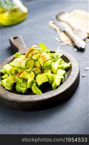 Salad with , avocado, cucumber and nuts on plate, top view