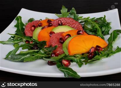 Salad with avocado, grapefruit, persimmon, pomegranate and arugula