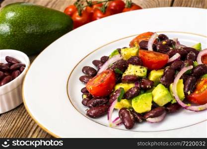 Salad with beans and avocado on background of old boards. Studio Photo. Salad with beans and avocado on background of old boards