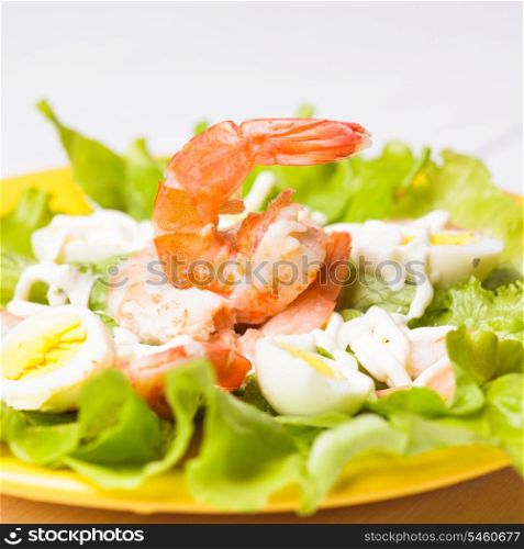 Salad with boiled shrimps, quail eggs and sauce