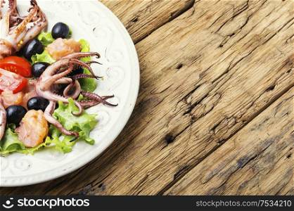 Salad with calamari, salmon and vegetables.Seafood concept. Fresh salad with seafood