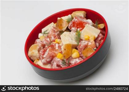 salad with cheese and tomato in a deep black cup on a white background. salad in a deep black cup