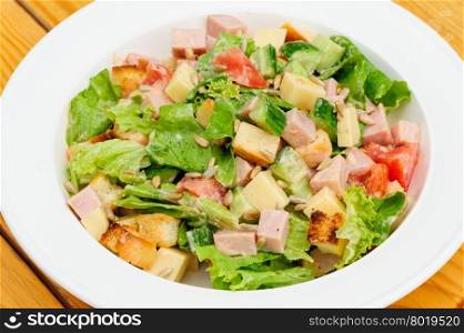 salad with cheese, ham fresh tomatoes, lettuce, sunflower seeds and crackers
