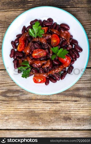 Salad with cherry tomatoes and red beans in spicy tomato sauce. Studio Photo. Salad with cherry tomatoes and red beans in spicy tomato sauce