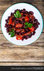 Salad with cherry tomatoes and red beans in spicy tomato sauce. Studio Photo. Salad with cherry tomatoes and red beans in spicy tomato sauce