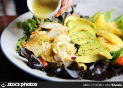 Salad with Chicken avocado and mango on wood background