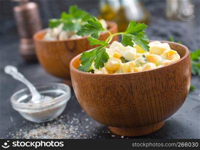 salad with corn and chicken in wooden bowl