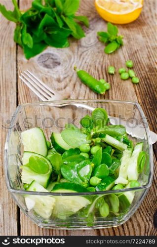 Salad with Cucumber, Purslane and Green Peas on Dark Disks Studio Photo. Salad with Cucumber, Purslane and Green Peas on Dark Disks