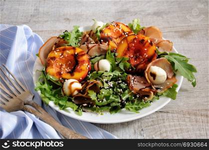 Salad with dried ham, grilled nectarine, mozzarella and arugula