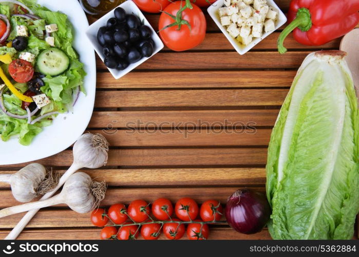 salad with feta cheese and fresh vegetables on wooden background