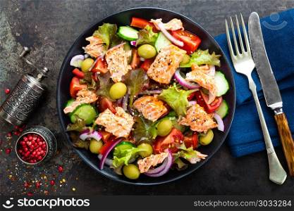 Salad with fish. Fresh vegetable salad with salmon fish fillet. Fish salad with salmon fillet and fresh vegetables on plate