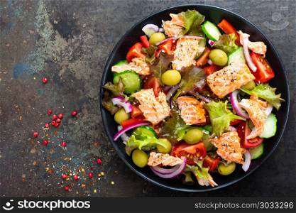 Salad with fish. Fresh vegetable salad with salmon fish fillet. Fish salad with salmon fillet and fresh vegetables on plate
