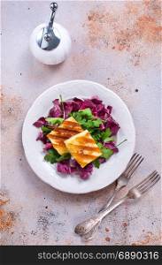 salad with fried cheese on white plate