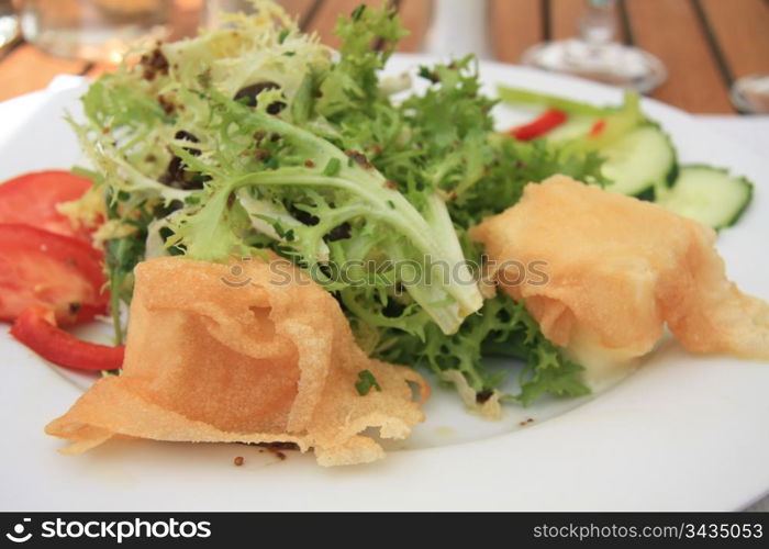 salad with fried goat cheese and tomato, french cuisine