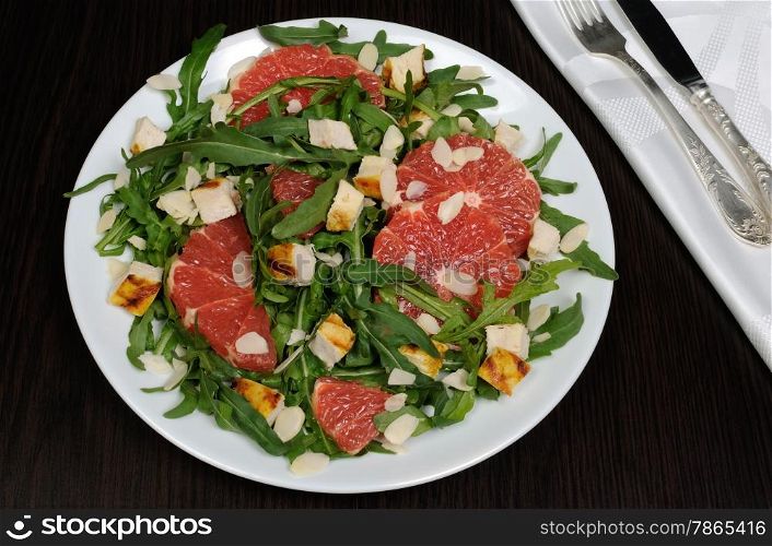 Salad with grilled chicken and arugula, grapefruit, almonds