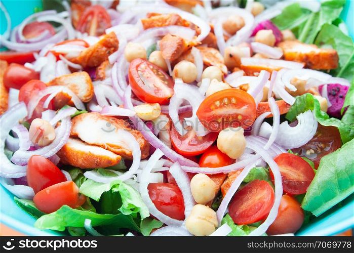 Salad with grilled chicken, cherry tomatoes, corn salad, chick peas, fresh lettuce and onion. Home made food. Concept for a tasty and healthy meal. Close up.