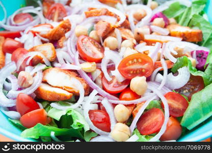 Salad with grilled chicken, cherry tomatoes, corn salad, chick peas, fresh lettuce and onion. Home made food. Concept for a tasty and healthy meal. Close up.