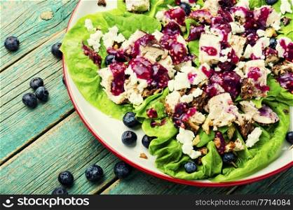 Salad with herbs, grilled chicken, nuts and blueberries. Chicken breast salad, greens, blueberries