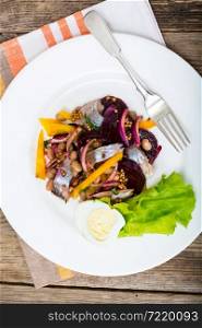 Salad with herring, beetroot, paprika, red onion, mustard and balsamic vinegar. Studio Photo. Salad with herring, beetroot, paprika, red onion, mustard and ba