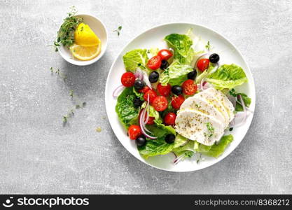 Salad with mozzarella cheese, cherry tomato, olives and romain lettuce, top view