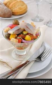 Salad with pieces of herring, white bread with vegetables and herbs