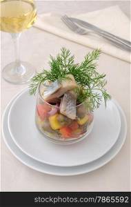 Salad with pieces of herring with vegetables and herbs