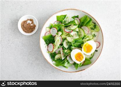 Salad with radish, cucumber, romaine lettuce and soft boiled egg, top view
