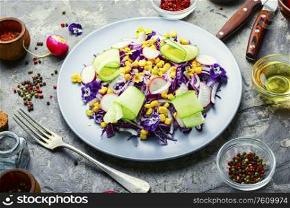 Salad with red cabbage, radish, corn, cucumber and flowers.Spring salad decorated with edible flowers.. Vegetable spring salad