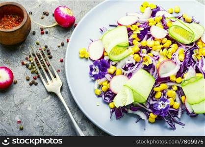 Salad with red cabbage, radish, corn, cucumber and flowers. Spring salad with edible flowers.