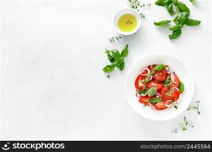 Salad with red ripe tomatoes, basil and olive oil, top view
