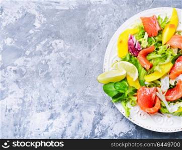 Salad with salmon,mango and fresh herbs. lettuce salad with fish