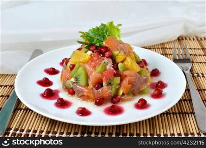 Salad with salmon of different fruits and pomegranate