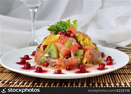 Salad with salmon of different fruits and pomegranate