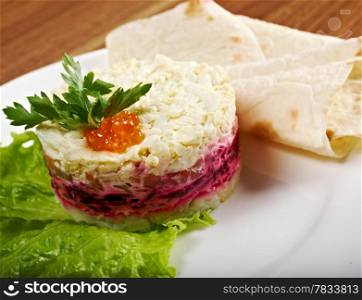 Salad with salmon with sauce and small cake.closeup