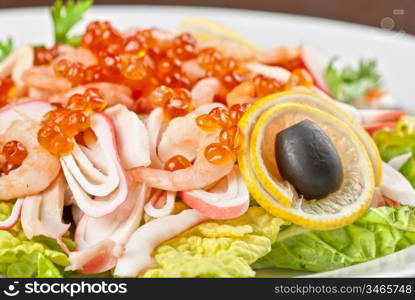 Salad with shrimps, caviar, calamaries, lettuce, lemon and olive