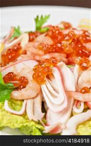 Salad with shrimps, caviar, calamaries, lettuce, lemon and olive