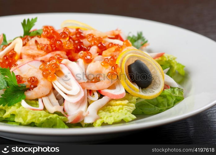 Salad with shrimps, caviar, calamaries, lettuce, lemon and olive