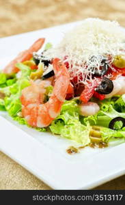 Salad with shrimps, caviar, calamaries, lettuce, olive, tomato and mozzarella